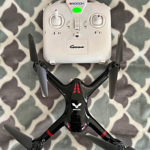 Black and red quadcopter drone with white top controller housing