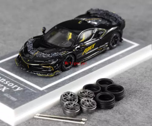 Black 1:64 diecast racing car model with spare wheels and tools on display