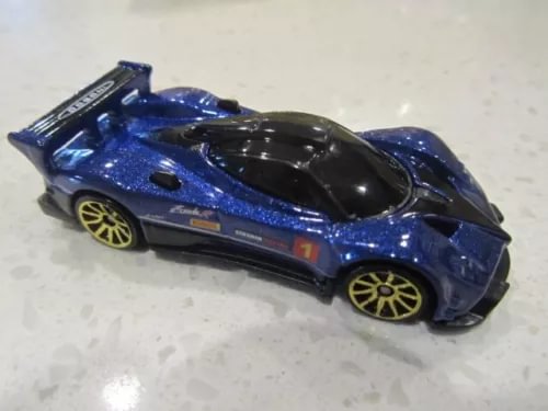 Blue diecast race car with black hood, yellow wheel rims, side number 1