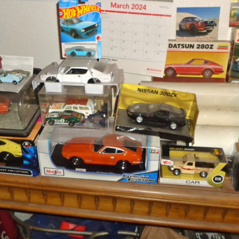 Diecast car set in retail boxes, including orange and black sports cars