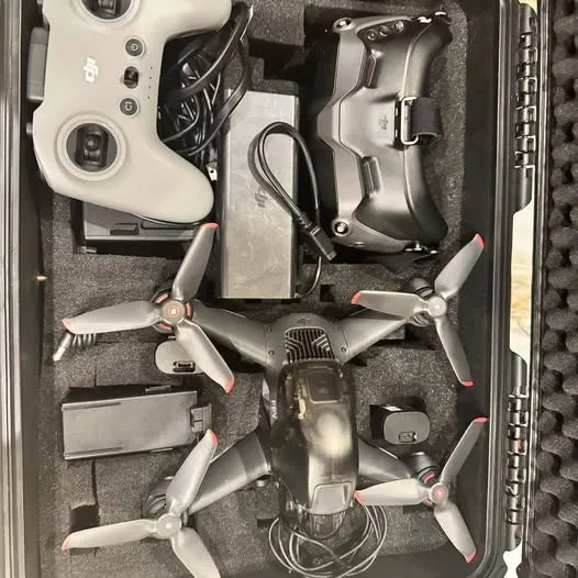FPV drone with four propellers, in a protective case, compact quadcopter body.