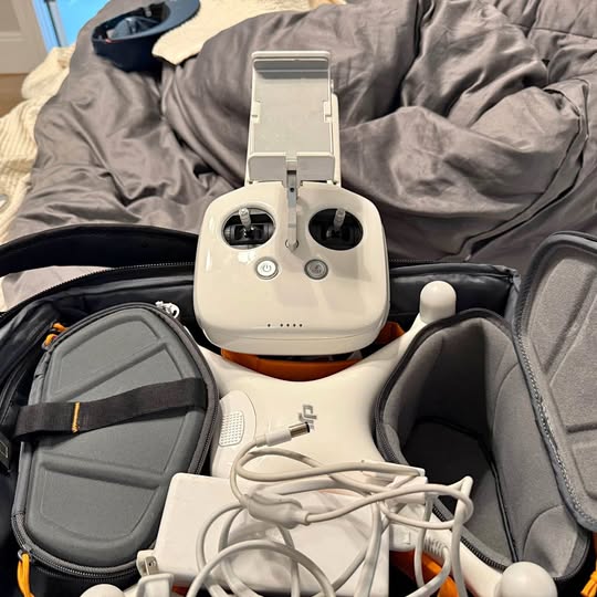 White drone remote controller with attached display and cables in a protective case
