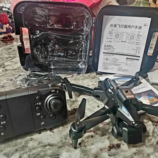 Drone with black remote controller and accessories, folding arms