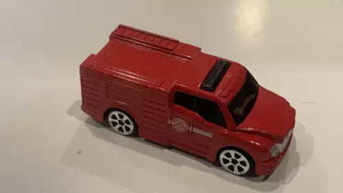 Red fire truck diecast toy, side view with black windows and wheels