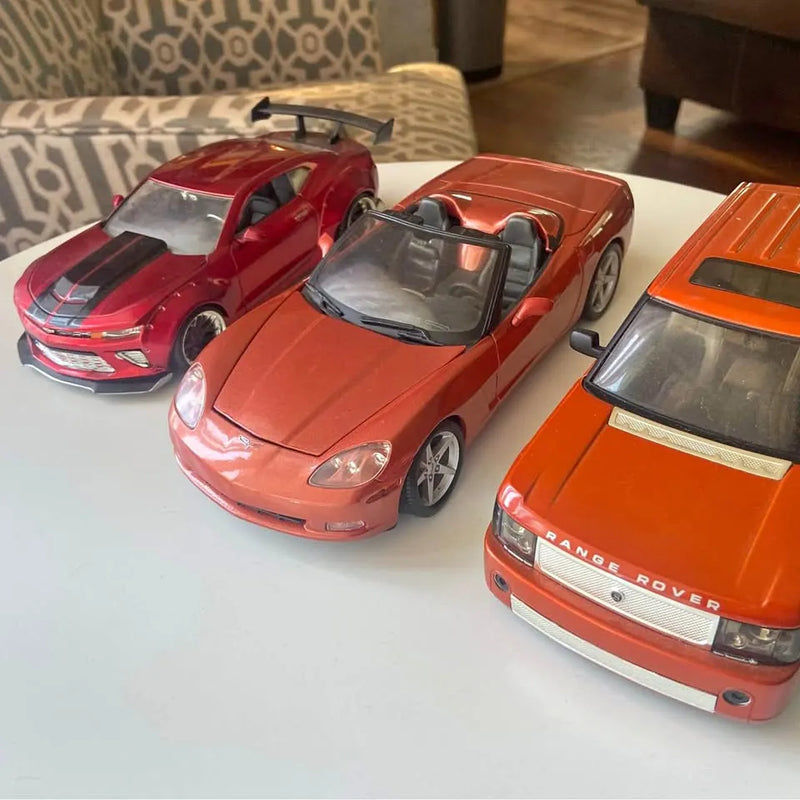 Diecast model cars, red and orange, three-car display