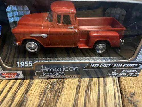 Red die-cast stepside pickup truck model, side view, in display box.
