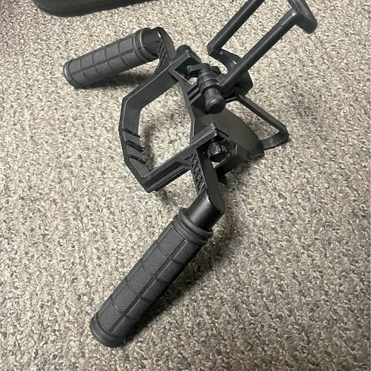 Handheld drone gimbal handle bracket with textured grip and adjustable mounting clamp