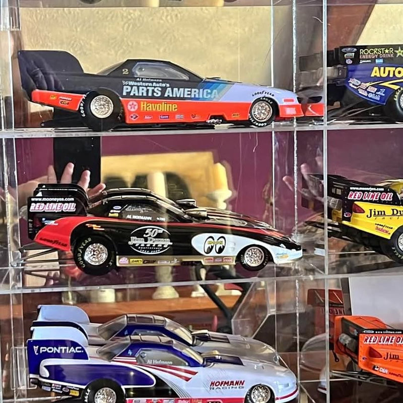 Diecast drag racing model cars in display case; black/orange and black/red