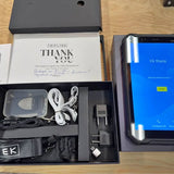 Drone accessory kit in open box: cables, charger, and adapter