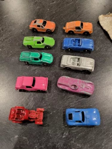 Assorted diecast metal toy cars, small vintage-style vehicles in multiple colors