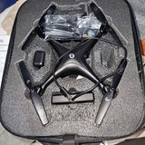 Compact black drone with four propeller arms and landing legs, inside protective carrying case