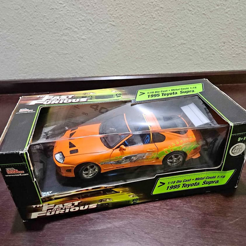 Boxed 1:18 die-cast 1995 Toyota Supra model car, orange with green graphics