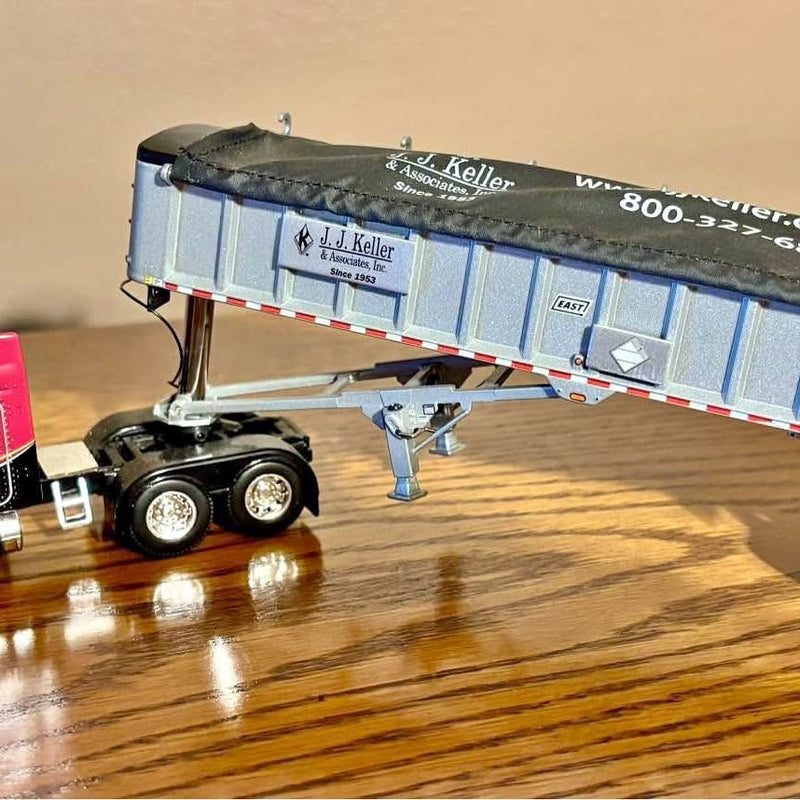 Diecast tractor-trailer replica with blue box trailer and black two-axle truck unit.