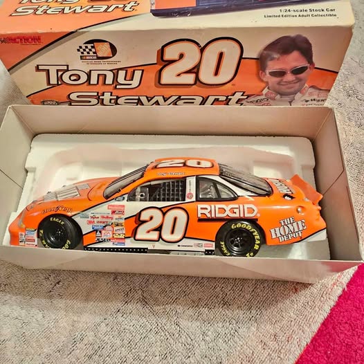 Orange Tony Stewart diecast race car #20 in open display box, front view