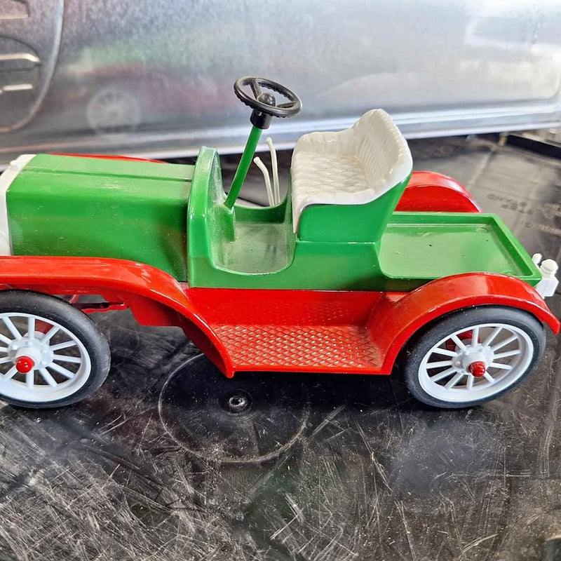 Green and red diecast vintage car with open top and white-spoke wheels