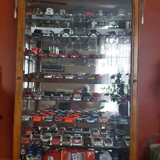Diecast car display case with multiple model cars on glass shelves