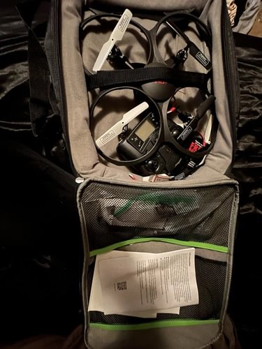 Drone with HD camera in gray storage bag with mesh pocket and documents
