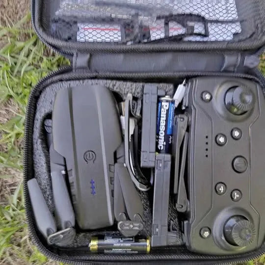 Gray drone controller and components in open zippered carrying case