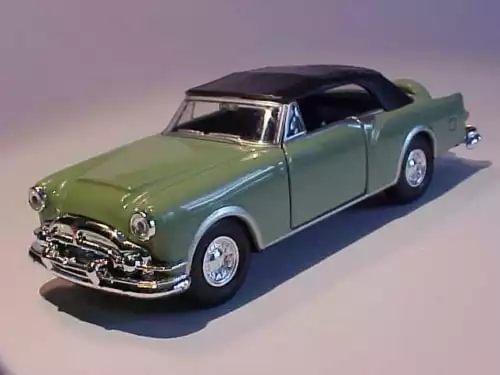 Mint green classic diecast car model with chrome grille, black roof, and whitewall tires