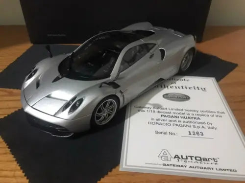 Silver 1:18 diecast sports car with black hood vents, front three-quarter view