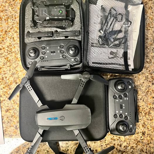 Mini drone with remote controller in zip storage case, gray body and controls