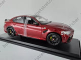Red diecast model car with black wheels, front-left view, replica sports sedan
