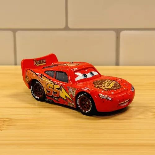 Red Lightning McQueen diecast race car with open-wheel detail, 1:55 scale