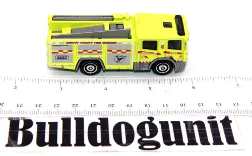 Yellow diecast fire engine truck with ladder and side compartments, side view