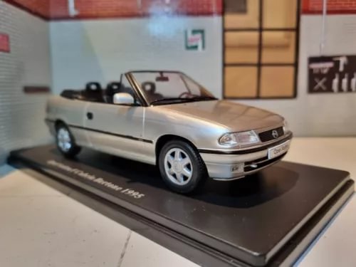 Silver convertible diecast model car on display base, front 3/4 view
