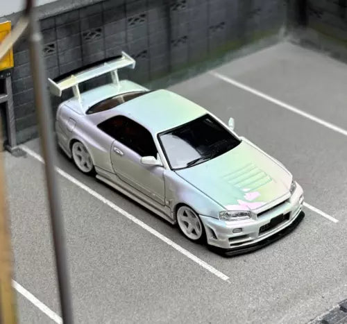 White diecast model car, front 3/4 view with detailed grille and headlights
