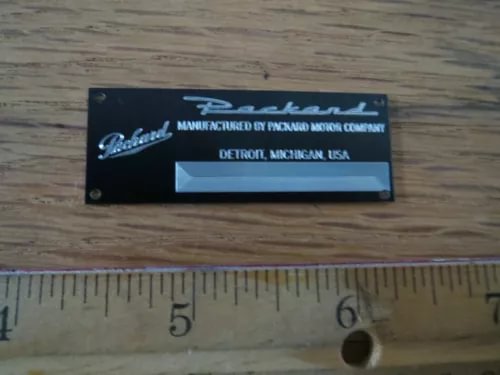 Blue metal display plaque with white lettering and rectangular nameplate window