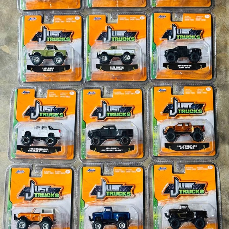 Diecast truck lot of 13 in orange blister boxes, assorted pickup truck models.