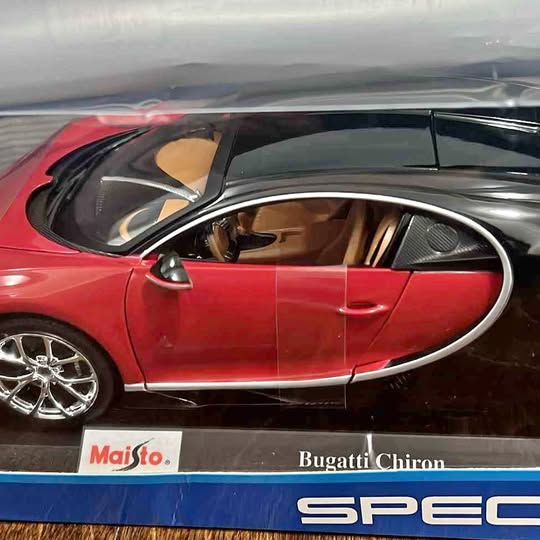 Red diecast sports car model with detailed interior, steering, and alloy wheels