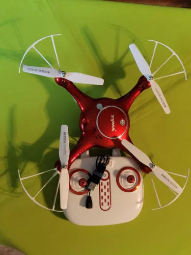 Red and white quadcopter drone with four propellers and camera sensor