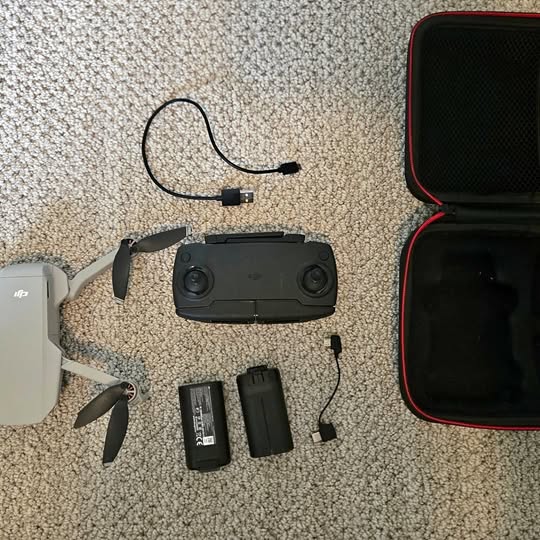 DJI Mavic Mini drone with propellers, two batteries, cables, and protective case