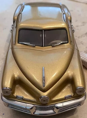 Gold 1:24 diecast car model with front grille and headlights, close-up view