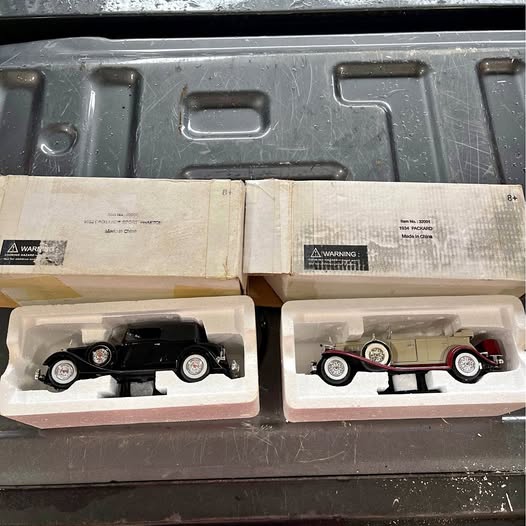 Diecast model car set in boxes, one black and one red, white wheels
