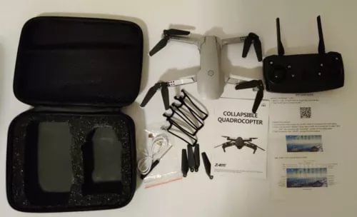 White quadcopter drone kit with carry case, WiFi remote controller, and accessories