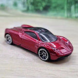Red diecast model car with black hood stripes, front three-quarter view