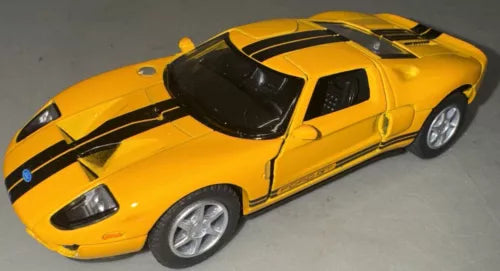 Yellow 2006 Ford GT diecast toy car, black stripe accents, front-left 3/4 view