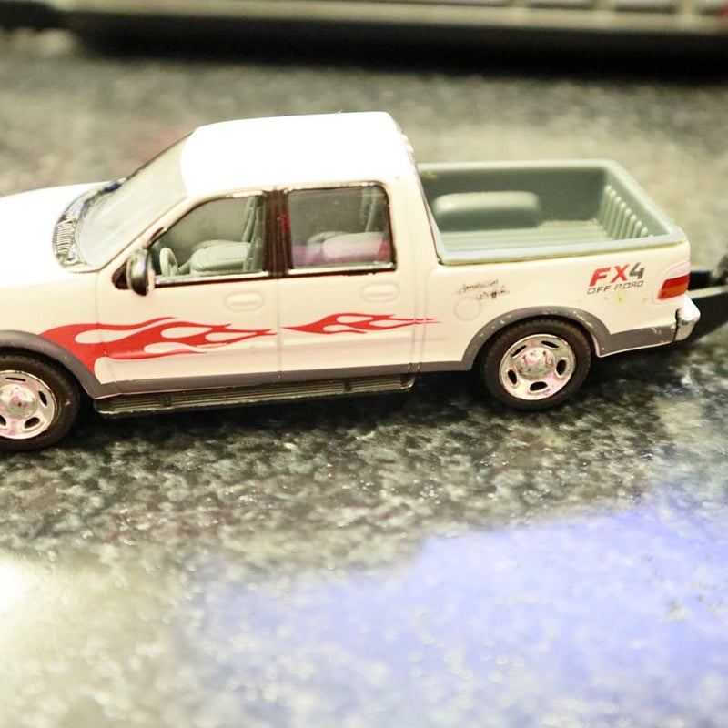 White diecast pickup truck with red flame decals and FX4 marking, side view