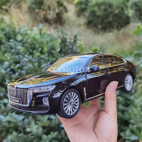 Black diecast sedan model with chrome grille, held in hand, detailed wheels