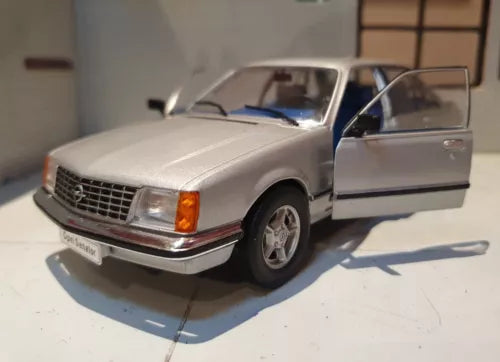 Silver diecast model sedan car, front-left view with driver door open