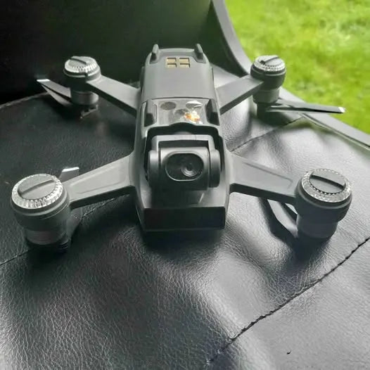 Drone with front camera, four propeller arms, and side control lights