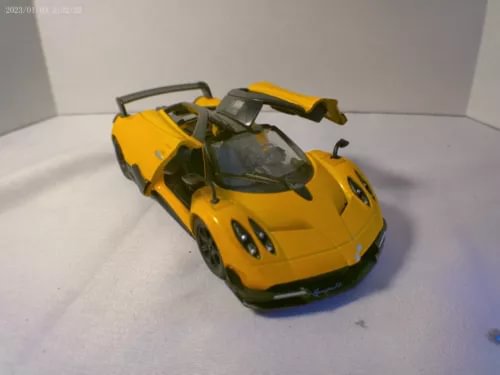 Yellow diecast sports car model with black hood and detailed wheels