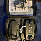 Compact drone in a zippered case with spare parts and cables, dark gray