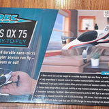Mini drone in open box, white and black body with spinning propellers