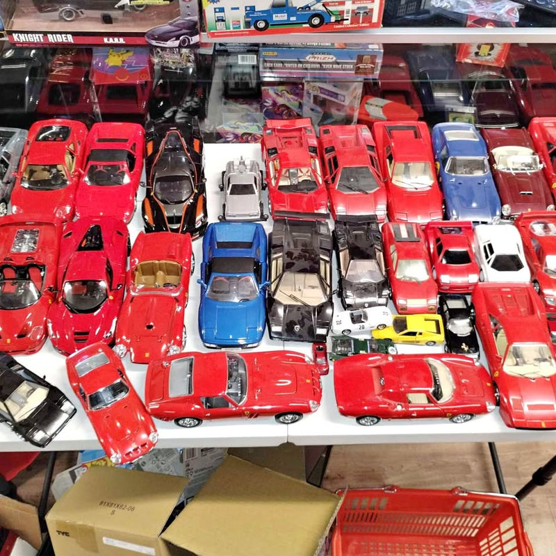 Diecast toy car assortment with many red cars and a few blue, black, and white vehicles