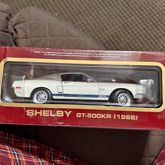 White diecast model car with blue racing stripe, in clear display box
