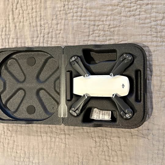 Foldable quadcopter drone in hard case, white and dark gray, top view